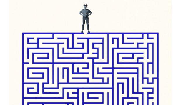 Mulher tentando decidir que caminho seguir em um labirinto