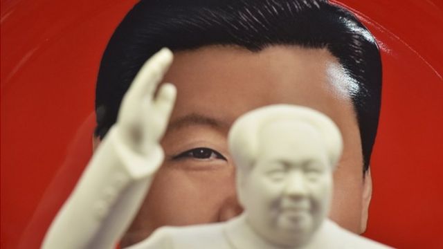 TOPSHOT - A decorative plate featuring an image of Chinese President Xi Jinping is seen behind a statue of late communist leader Mao Zedong at a souvenir store next to Tiananmen Square in Beijing on February 27, 2018. China's propaganda machine kicked into overdrive on February 27 to defend the Communist Party's move to scrap term limits for President Xi Jinping as critics on social media again defied censorship attempts. The country has shocked many observers by proposing a constitutional amendment to end the two-term limit for presidents, giving Xi a clear path to rule the world's second largest economy for life.