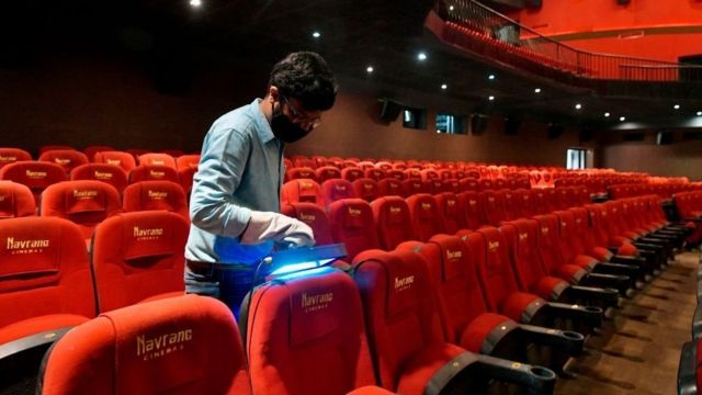 A vendor demonstrates the sterilisation process with an ultraviolet light device on auditorium seats in Bangalore on October 8, 2020