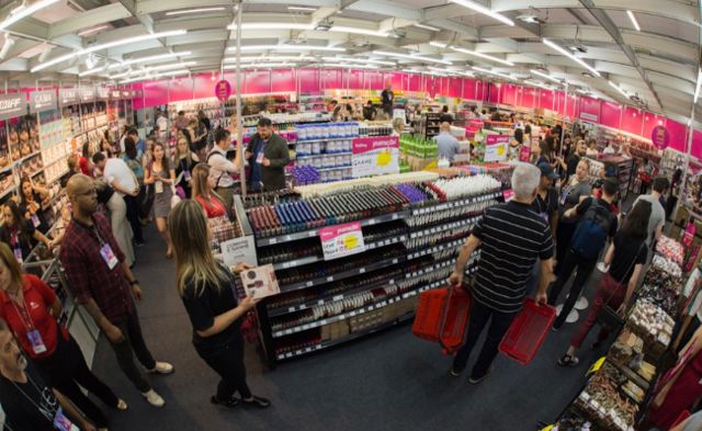 Consumidores comprando produtos de beleza em feira