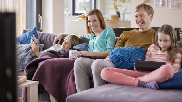 Family on devices while watching TV