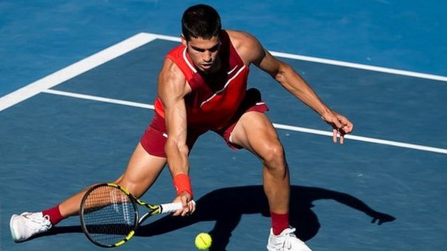 Carlos Alcaraz stretches for a half-volley during the 2022 Australian Open