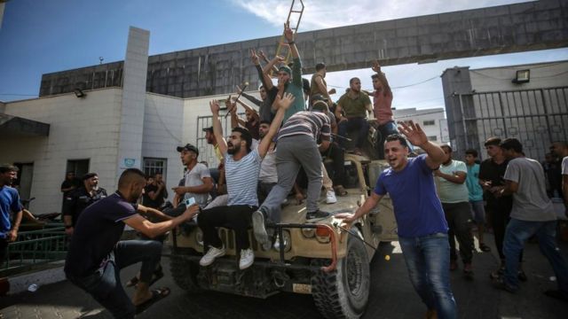 Palestinians on top of an Israeli military vehicle in Gaza