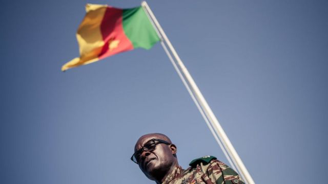 Cameroonian general Donatien Nouma Melingui, in charge of military operations in the South-West Region of Cameroon stand by di kontri national flag