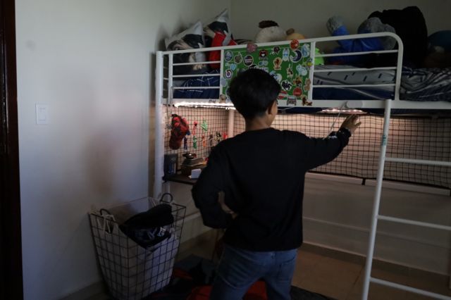 El hijo de Montserrat Caballero, presidenta municipal de Tijuana, muestra su habitación en la casa en la que vive en el 28 Batallón de Infantería de la ciudad mexicana en agosto de 2023.