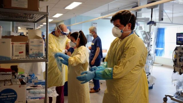 Trabajadores de la salud se preparan para recibir más pacientes en un hospital en Inglaterra