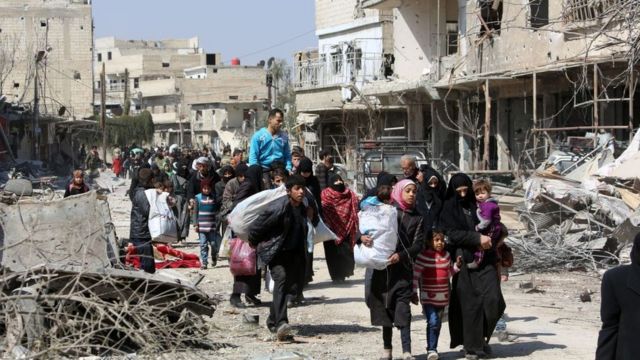 Syrian civilians leave the rebel-held town of Jisreen in the southern Eastern Ghouta during a government offensive (17 March 2018)