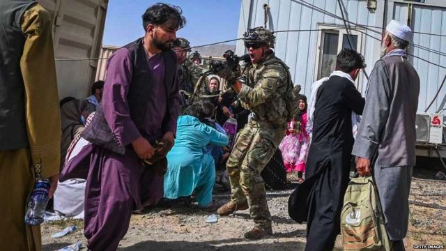 काबुल के एयरपोर्ट पर एक अमेरिकी सैनिक ने एक अफ़ग़ान यात्री पर अपनी बंदूक तान दी