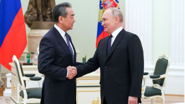 El jefe de la diplomacia china, Wang Yi, y el presidente ruso, Vladimir Putin.