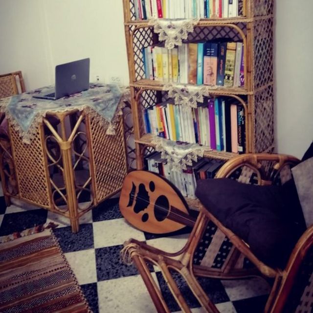 Uma estante de livros e um instrumento musical no chão