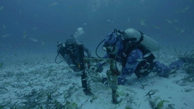 Buzos instalan un dispositivo de grabación submarina en el fondo marino cerca de las Seychelles.