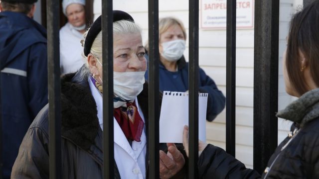 женщина за больничной оградой