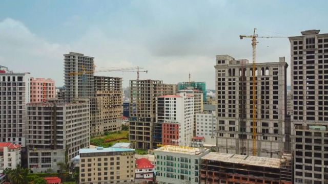 unfinished high-rise building development with crane in background