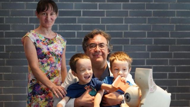 Olena is pictured with Professor Rejdakher and her sons, Nazar and Timur Sielihzjanov, who play with a prosthetic eye model having undergone eye-saving surgery themselves