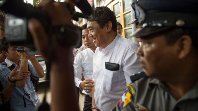 Than Htut Aung (C), CEO of the Eleven Media Group, is escorted by police while leaving the court in Yangon on November 11, 2016