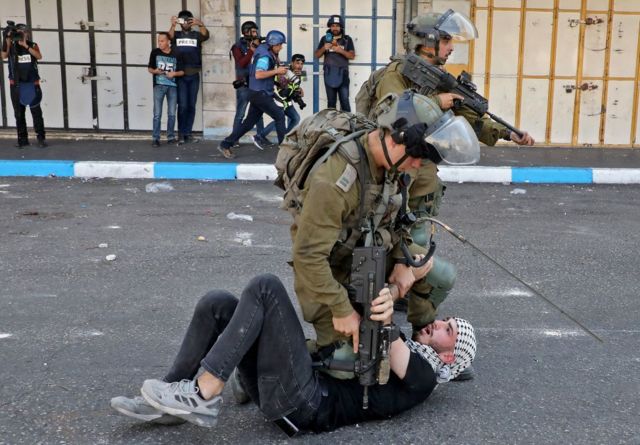 Un soldado israelí reduce a un manifestante palestino.