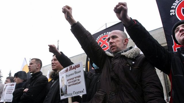 Extremistas nacionalistas rusos sostienen carteles contra los inmigrantes durante una protesta.