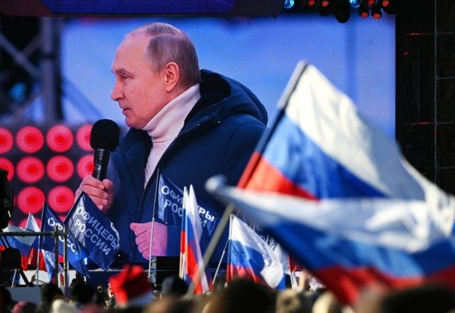 Tổng thống Nga Vladimir Putin xuất hiện trên màn hình khi ông có bài phát biểu trong buổi hòa nhạc đánh dấu kỷ niệm tám năm ngày Nga sáp nhập Crimea ngày 18 tháng 3 năm 2022