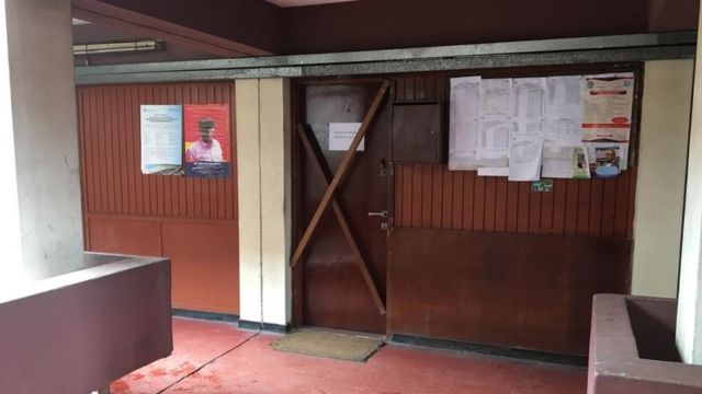 Une porte de bureau est bloquée par deux planches de bois