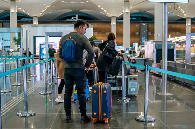 مسافران در صف بررسی امنیتی در فرودگاه