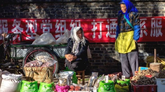 Local women sell produce in the market. Zhongyi market, located at the southern gate of Dayan ancient city, in Lijian, Yunnan Province in China