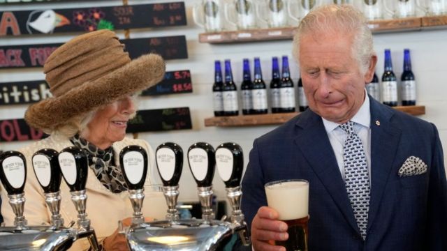 Camilla, duquesa da Cornualha, observa como o rei Charles, príncipe de Gales, reage a uma cerveja ruim que ele fez na cervejaria Quidi Vidi, localizada em uma vila de pescadores no extremo leste de St Johns, em 2020