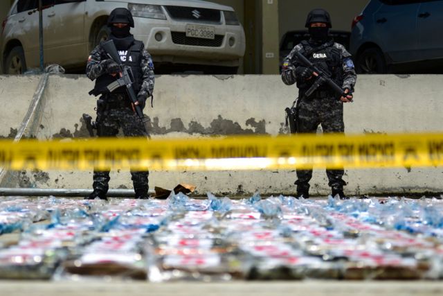 Policías antinarcóticos ecuatorianos montan guardia junto a paquetes de cocaína de un cargamento de 3 toneladas incautado en un contenedor de plátanos, en el puerto de GuayaquilPolicías antinarcóticos ecuatorianos montan guardia junto a paquetes de cocaína de un cargamento de 3 toneladas incautado en un contenedor de plátanos, en el puerto de Guayaquil