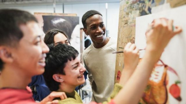 Pessoas sorrindo enquanto pintam quadro