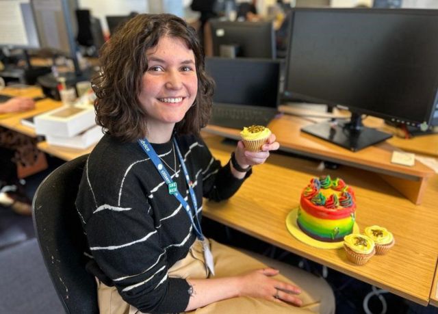Mulher em escritório com cupcakes e bolos