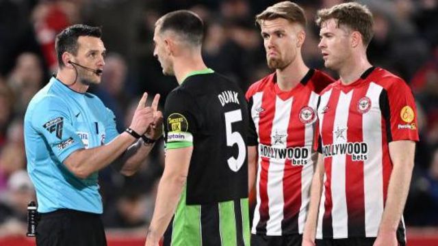 Referee Andy Madley speaks with Lewis Dunk