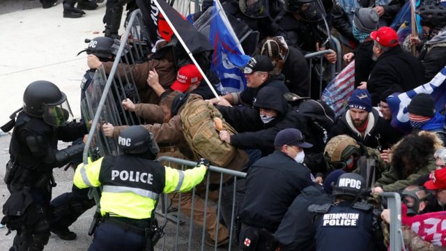 Uma multidão se aglomera contra as forças de segurança perto do Capitólio em Washington
