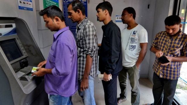 एटीएम से पैसे निकालते लोग