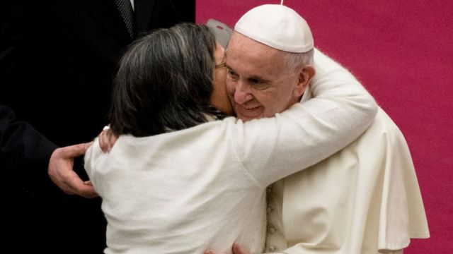 El papa Francisco abrazando a una fiel.