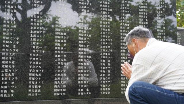 Un hombre reza frente a un monumento en Okinawa que recuerda a las víctimas de la guerra.
