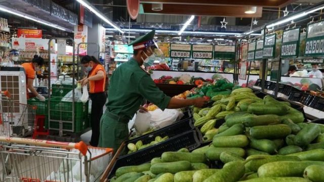 Một quân dân đang chọn đồ ở siêu thị TP HCM. Nhiều người dân không hiểu vì sao chính quyền phải đưa quân đội thay shipper "đi chợ hộ".