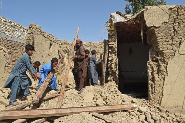 Residents remove debris of their damaged mud houses following an earthquake in the remote mountainous district of Harnai, Pakistan, on 7 October 2021