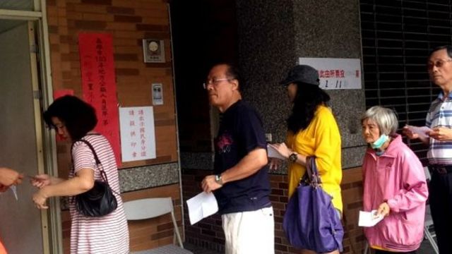 四年前的九合一地方选举，选民们在票站外排队。