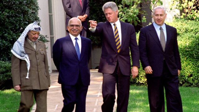 Mr Netanyahu (dir.), Yasser Arafat (esq.), Rei Hussein, da Jornânia (centro-esq.) e Bil Clinton (centro-dir.), em outubro de 1996 na Casa Branca