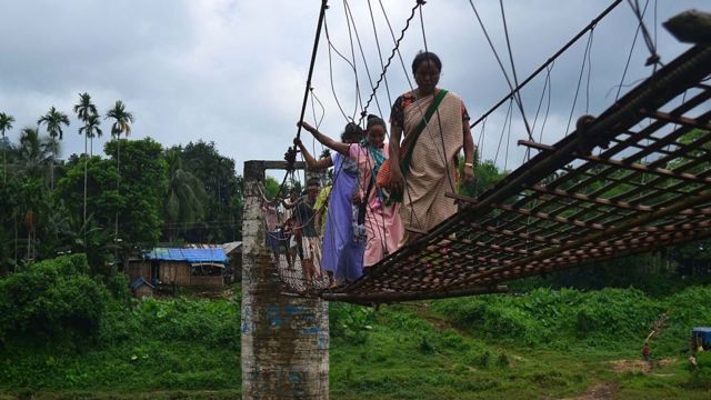 মেঘালয়ে শ্রী নদীর ওপর একটি সেতু পার হচ্ছেন কিছু গ্রামবাসী