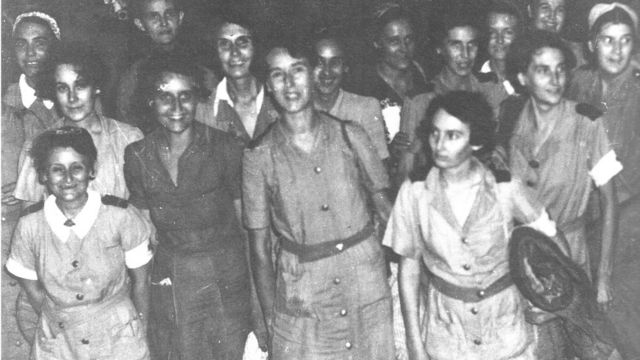 Black and white photo of a separate group of nurses arriving back in Singapore after evacuation from Sumatra in 1942