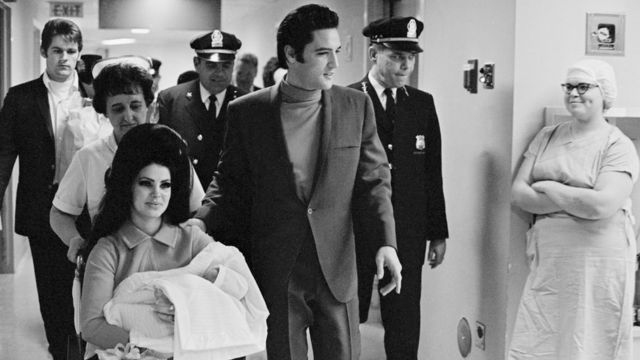 La familia Presley saliendo del hospital con Lisa Marie en brazos, recién nacida, en una foto en blanco y negro.