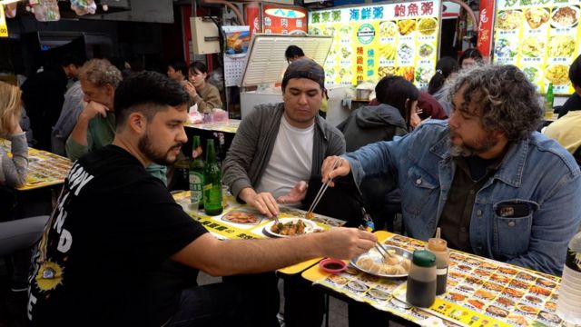 Paraguayos cenando en un mercado nocturno.