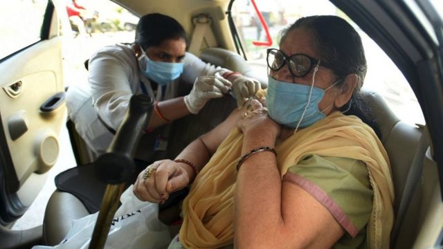 Uma mulher recebe uma dose da vacina Covid-19 em um local de vacinação drive-thru em Noida, Índia, maio de 2021