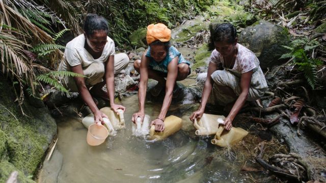 Mulheres pegam água no Timor Leste