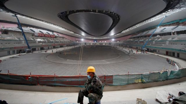 A construction worker sits on the National Speed ​​Skating Oval, known colloquially as the 