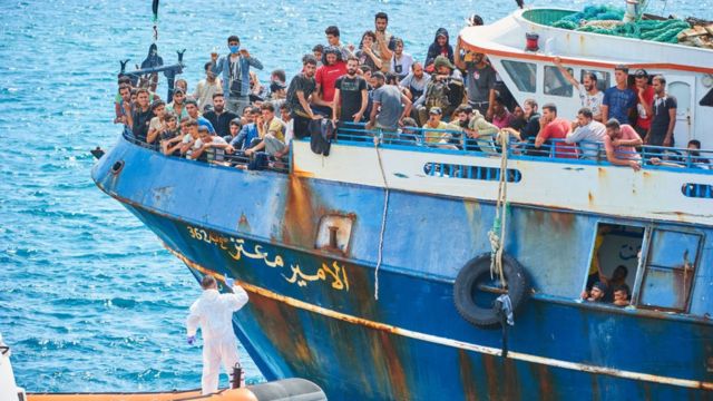 Um grupo de imigrantes chegando na Itália de barco