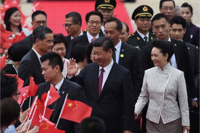 Waa markii madaxweyne Xi Jinping oo dhexda ka muuqda uu ka dagay garoonka ugu wayn magaalada Hong Kong isagoo ay weheliso xaaskiisa Peng Liyuan