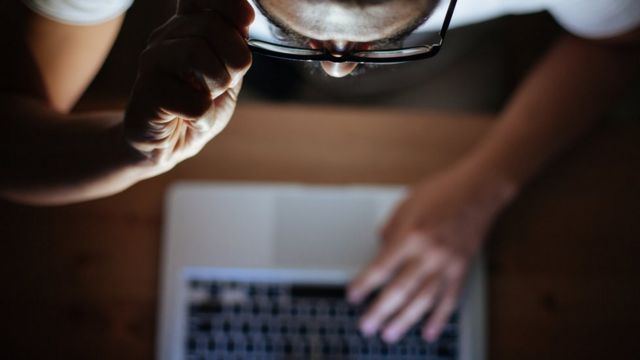 hombre mirando la pantalla de su computadora.