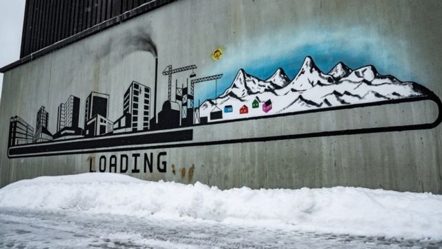 grafite em Nuuk mostra prédios e chaminés substituindo a paisagem natural da ilha