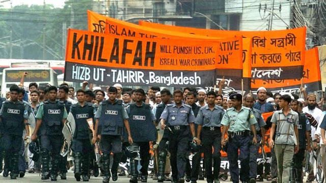 Hizb-ut Tahrir üyelerinin Bangladeş'teki bir gösteride taşıdığı pankart: "Hilafet Savaş Suçlusu ABD, İngiltere ve İsrail'i Cezalandıracak".